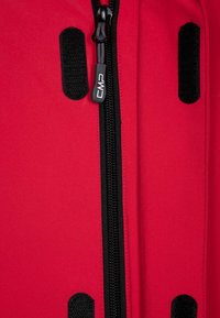 Abrigo exterior rojo con un zipper negro, tirador con el logo de CMP y detalles de Velcro negro en los costados. El material parece suave con un ligero brillo.