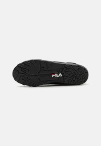 Semelle noire de basket avec caoutchouc texturé, présentant un motif de semelle distinct et un détail de logo rouge. Durable et conçue pour l'adhérence.