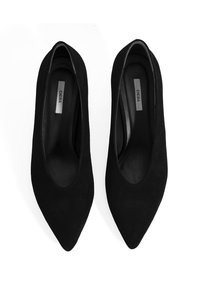 Zwarte su�ède pumps met spitse neus, een gladde textuur en zonder zichtbare hardware. Het interieur heeft een zachte voering.