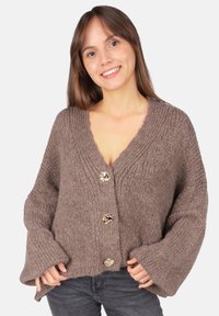 Brauner Strickcardigan mit tiefem V-Ausschnitt, langen Glockenärmeln und drei dekorativen Knöpfen in Goldoptik vorne. Weicher, strukturierter Stoff.