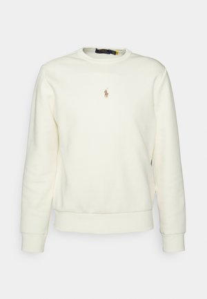 Bluza z kremowym okrągłym dekoltem, długimi rękawami i małym brązowym logo gracza polo na środku klatki piersiowej.