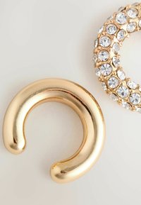 Gul cirkul�ær ørering komponent med en glat, skinnende overflade, sammen med et stykke med rhinestones, der har en lignende form.