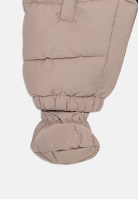 Beige gewatteerde jas met een mouw met elastische manchet en gerimpelde pols, ontworpen voor warmte en comfort.