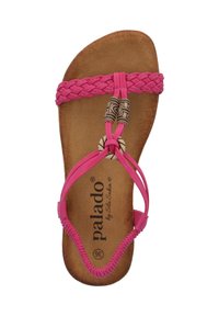 Sandale tressée rose avec une semelle plate, ornée de perles décoratives et d'un logo sur une semelle intérieure brun clair. Fabriquée avec des matériaux flexibles.