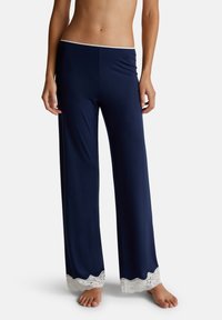 Navy loungebroek van zacht stof met een wijde pijp ontwerp, met een gegolfde witte kantafwerking aan de onderkant. Geen extra details.