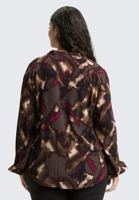 Langärmlige Bluse in einem dunklen, abstrakten Muster mit Burgundy-, Braun- und Cremetönen, gefertigt aus einem leichten, strukturierten Stoff.