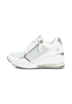 Zapatilla blanca y plateada con paneles de malla, cremallera lateral, cordones y suela con amortiguación visible de aire, mostrada desde el lado exterior.