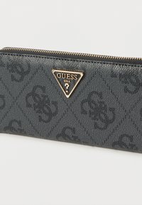 Portafoglio nero testurizzato con una piastra triangolare del logo in oro. Presenta una chiusura con zip e un motivo delicatamente in rilievo su tutto il tessuto.