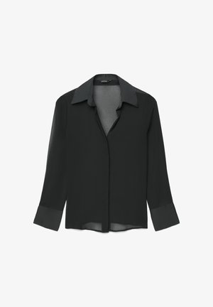 Blouse noire à manches longues avec un col classique, tissu transparent et fermeture à boutons. Les poignets présentent un détail de texture contrastante.