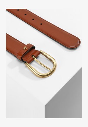Bruine leren riem met een gouden metalen gesp, kenmerkend door een lichte textuur en verschillende gaten voor aanpassing. Versierd met een logo-detail.