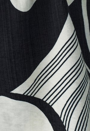 Crni i off-white tekstil s apstraktnim oblicima; sadrži debele zakrivljene bijele oblike i tanke crne pruge, teksturirana površina tkanine.