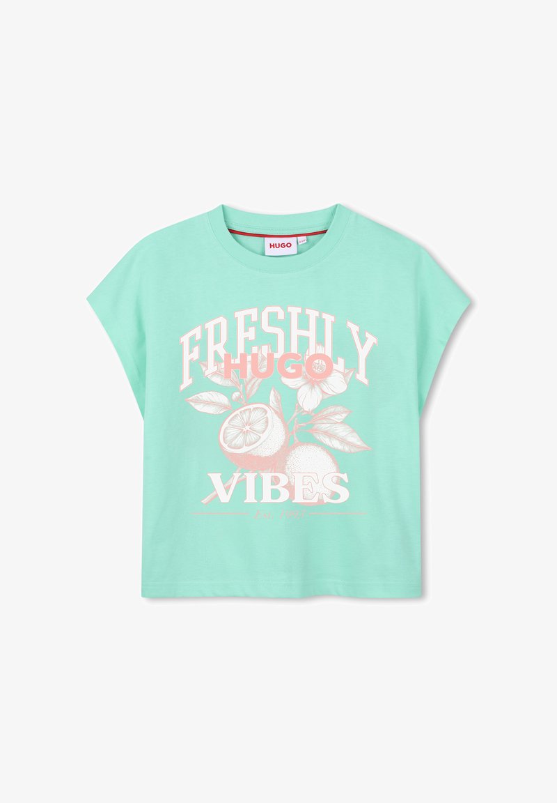T-shirt court vert menthe avec le texte "FRESHLY VIBES", un motif de fruits d'agrumes et de fleurs, et le nom de la marque "HUGO" sur le devant.