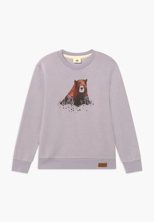 Jasnofioletowy długi rękaw sweatshirt z grafiką brązowego niedźwiedzia otoczonego roślinami z przodu oraz małą skórzaną metką marki blisko dolnego skośnego.