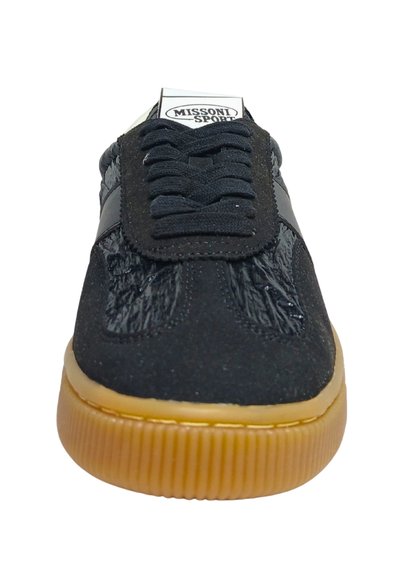 Baskets noires avec une tige texturée, dotées d'une bande noire brillante et d'une semelle extérieure en caoutchouc gomme contrastante. Fermeture lacée à l'avant et languette rembourrée.