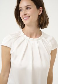 White short-sleeve blouse featuring a pleated design at the neckline, smooth texture, and a comfortable fit. Simple and elegant in style.