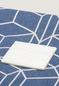 Blue fabric wallet featuring a geometric white pattern and a textured, cream-colored label with embossed text "JOHNNY ULRAN."
