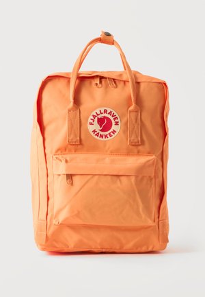 Sac à dos rectangulaire orange avec poche avant zippée, deux poignées supérieures avec bouton-pression, et écusson rond avec silhouette d'animal et texte.