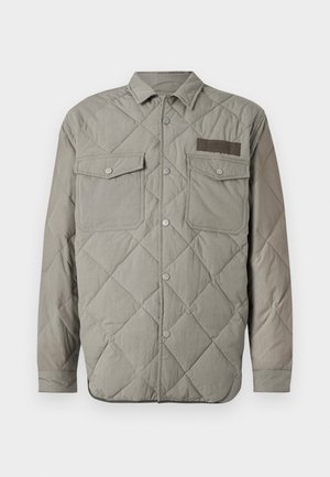 Quilted long-sleeve shirt jacket in light gray, featuring two chest pockets, snap buttons, and a textured patch with "REPLAY" branding.
