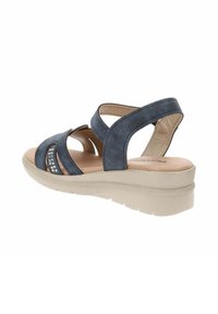 Sandal in blu navy realizzato in materiale scamosciato, con cinturini larghi, design a intaglio, abbellito da un accento argentato e una suola piatta beige.