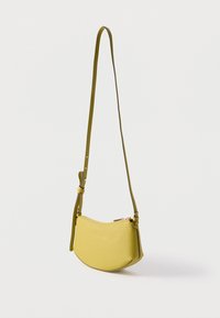 Κίτρινο-πράσινο δερμάτινο τσαντάκι ώμου με ρυθμιζόμενο λουρί και χρυστό φερμουάρ, τοποθετημένο πάνω σε λευκό φόντο.