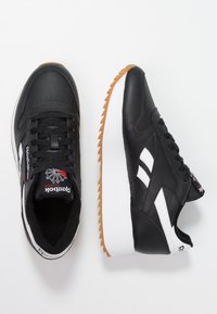 Czarne skórzane sneakersy z białymi akcentami, okrągłym noskiem, fakturowaną podeszwą i detalem z logo. Posiadają wyściełany kołnierz oraz perforowany wzór.