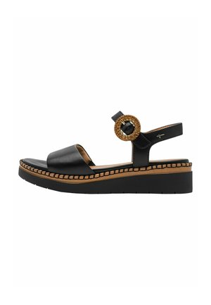 Zwarte leren sandaal met brede band, gevlochten cirkelvormig accent en contrasterende tan-achtige stiksels op een robuust zwart plateauzool.