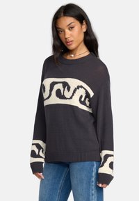 Maglione lavorato a maglia grigio scuro con motivo a onde color crema sul petto e sulle maniche, dotato di scollatura a girocollo e polsini e orlo a costine.