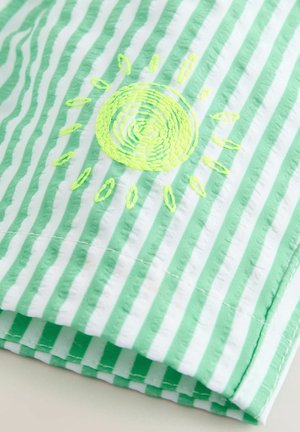 Green and white striped fabric with a textured finish, featuring a circular embroidered sun in bright neon yellow and matching rays.