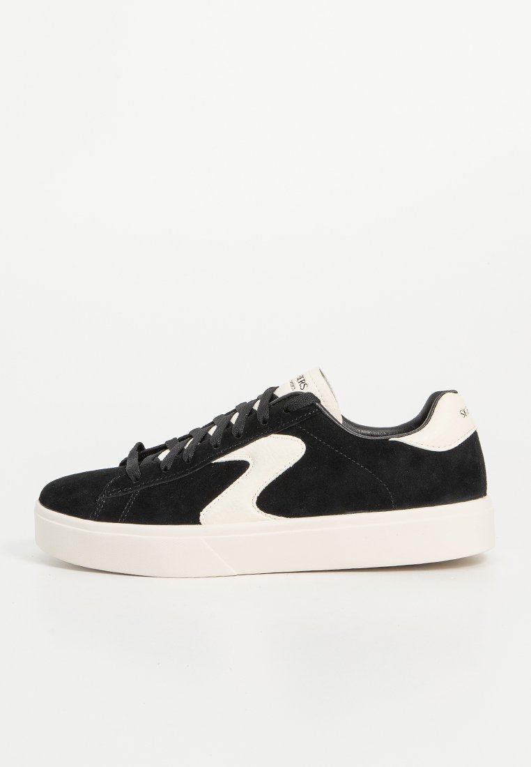 Schwarze Wildleder-Sneaker mit cremefarbenen Akzenten, runder Zehenform, Schnürdesign und einer dicken weißen Gummisohle. Niedriges Profil mit Logodetails.