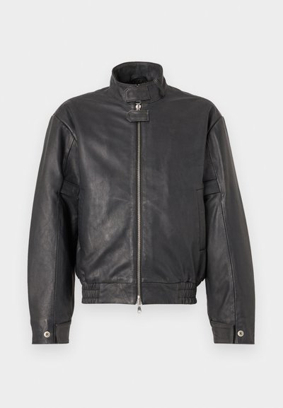 Veste en cuir noir avec col montant, fermeture éclair sur le devant, ourlet élastiqué et poches latérales. Texture lisse avec un minimum de détails.