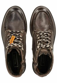 Bottines en cuir brun avec un bout arrondi, des détails cousus et un laçage noir et blanc avec œillets. Comprend une étiquette de marque.