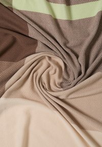 Struktureret stof i tan, brune og lysegrønne striber, med en blødvævet diagonal mønster og en subtil glans.