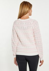 Hellrosa Pullover mit strukturiertem Muster, weißen Streifen, gerippten Bündchen und Saum sowie offenen Strickdetails.