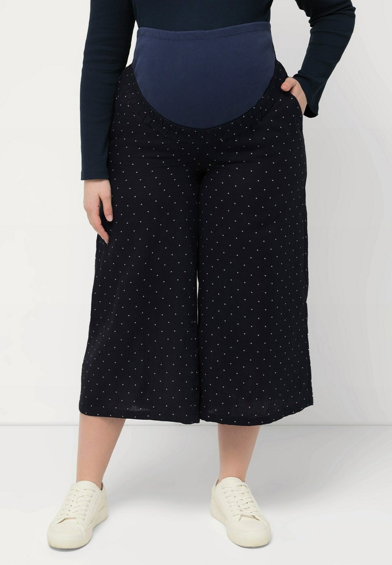 Culottes navy a pois con un ampio elastico in vita, dotati di tasche laterali e realizzati in un tessuto leggero e fluido, adatto alle giornate calde.