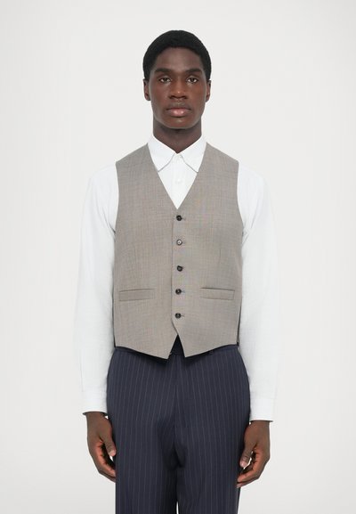 Grå tilpasset vest med V-hals, med seks knapper og to frontlommer, brukt over en hvit skjorte med krage, paret med benklær med striper.