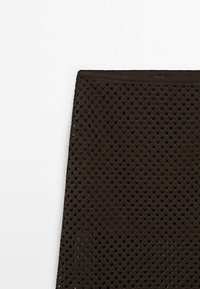 Brauner, gestrickter Rock mit einem Wabenmuster. Leichte Textur und elastischer Bund. Einfaches, figurbetontes Design.