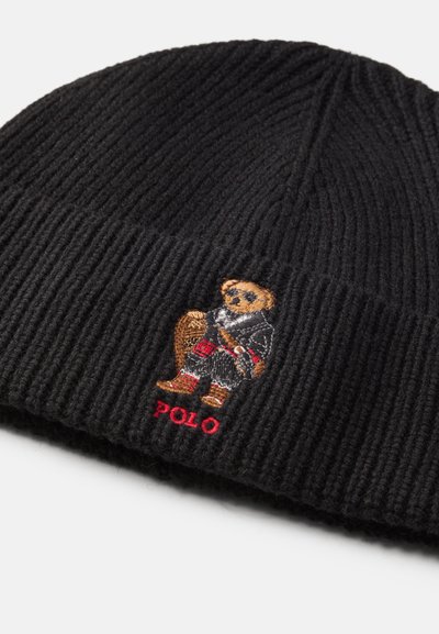 Gorro de malha preto com textura canelada, apresentando um urso bordado com um traje vermelho e preto e o texto "POLO" em vermelho.