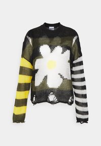 Pull en maille à tissage lâche. Comprend un grand motif de marguerite blanche, des motifs camo verts et noirs, et des manches rayées jaune et noir.