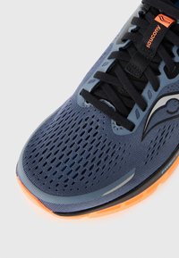 Men's running shoe with a dark blue mesh upper, ventilated design, black laces, reflective accents, and an orange rubber sole.