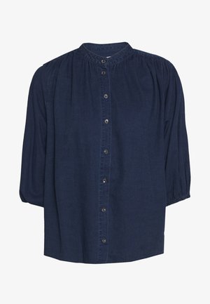 Blouse bleu foncé à boutons, avec empiècement froncé, manches trois-quarts et col rond.