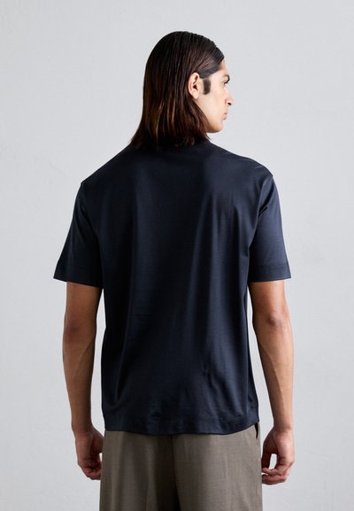 Zwarte T-shirt met korte mouwen van gladde stof, met een ronde hals en een ontspannen fit, getoond vanuit de achterkant met minimale details.