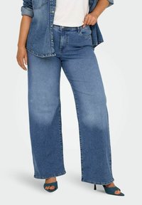 Jeans de mezclilla de un azul claro, de pernera ancha y cintura alta, con bolsillos laterales, un diseño minimalista y un lavado ligeramente desgastado.