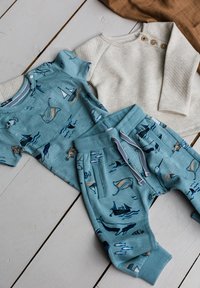 Helles blaues Baumwoll-Outfit mit aquatisch inspirierten Prints; umfasst ein Kurzarmoberteil mit Knöpfen und passende Sweatpants mit Taschen.