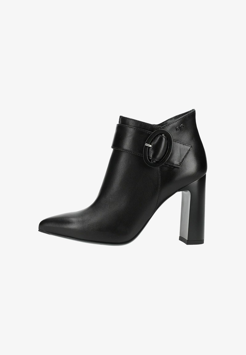 Bottine noire en cuir avec bout pointu, talon carré et large bride présentant une grande boucle ronde sur le côté.