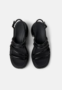 Black leather sandals with a rounded toe, featuring multiple crossed straps, an ankle strap, and a low heel. No visible patterns or hardware.