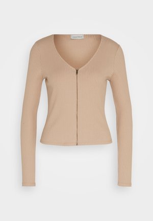 Beež ribaga pusa pikkade varrukatega flare-lõikega ja V-kaelusega. Esiosal on tõmblukk ning peen tekstuur, valmistatud venivast kangast.