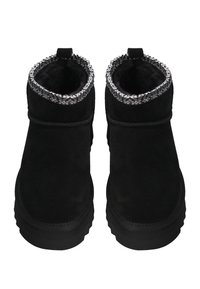 Para czarnych botków sięgających kostki z grubą podeszwą i szarym, wzorzystym futerkiem widocznym na górze.