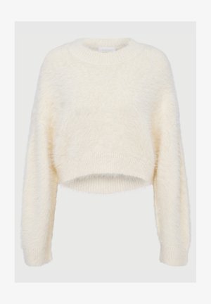 Skórzana bluzka w miękkim, puszystym kremowym materiale. Posiada okrągły dekolt i prążkowane mankiety. Prosty design bez wzorów czy akcentów.