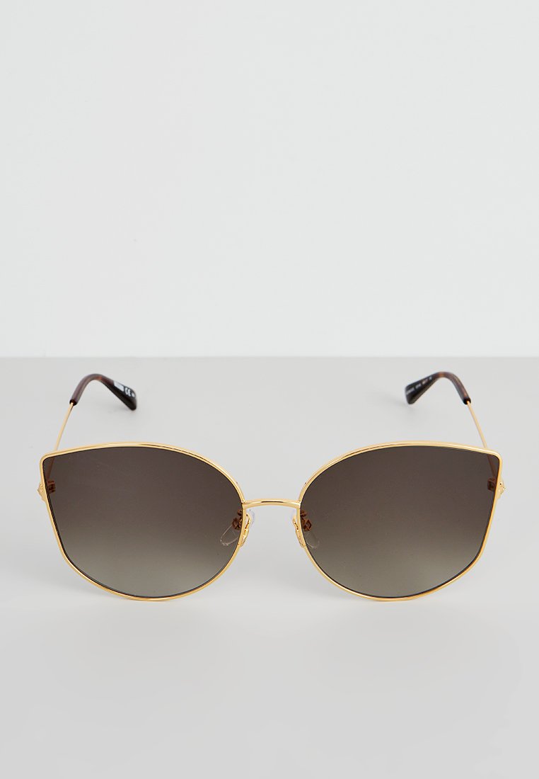 Goldfarbene Sonnenbrille mit übergroßen, kantigen, dunklen Gläsern. Dünne Bügel mit einem verlaufenden Braun-Finish. Minimalistisches Design.