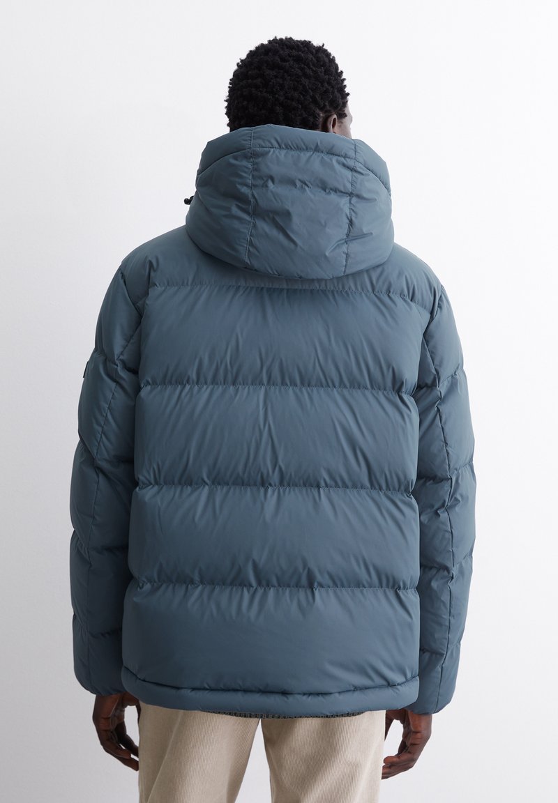 Blauer Pufferjacke mit hohem Kragen und schlankem Design. Verfügt über horizontale Nähte und eine Kapuze, aus wasserabweisendem Material.